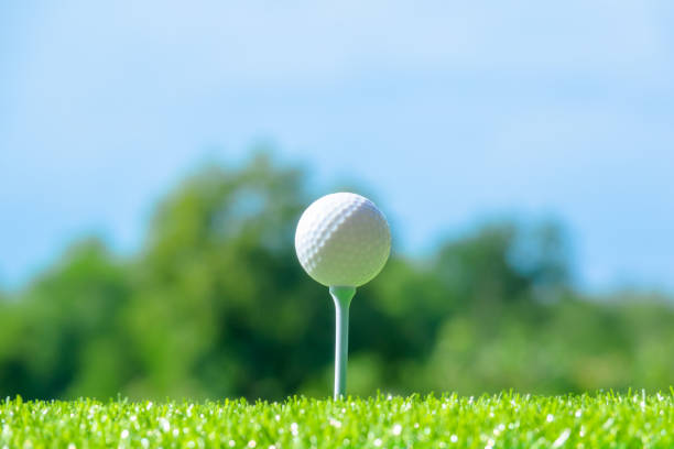 istock Golf ball sitting on tee on sky blue or azure sky and cloud background 958065294