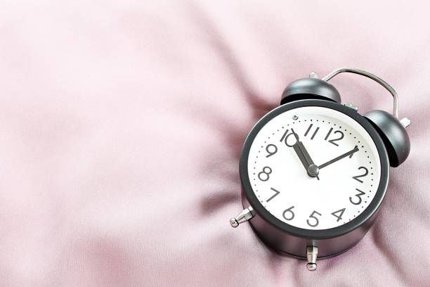 istock Top view image of black retro alarm clock on bed in morning, ready for adding or mock up 958070366