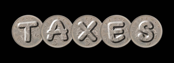 istock TAXES written with old British coins on black background 958073698