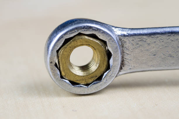 istock Metric screw and key on a wooden table. Mechanical accessories in the locksmith workshop. Light background. 958074550