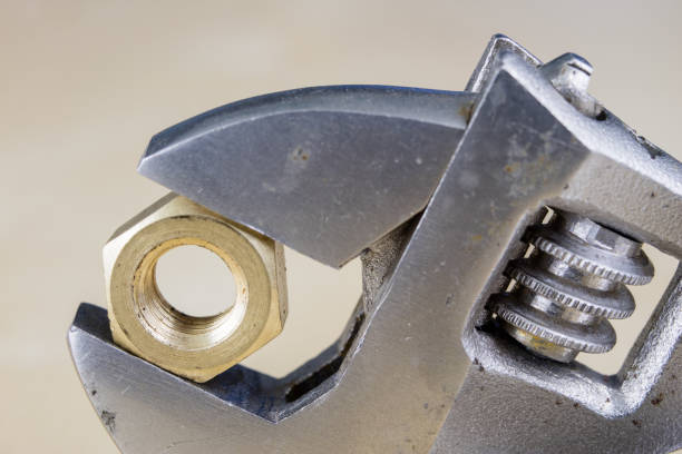 istock Metric screw and key on a wooden table. Mechanical accessories in the locksmith workshop. Light background. 958078016