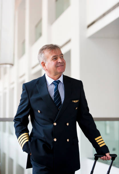 istock Experienced Senior pilot pulling his luggage in the airport terminal 958081826