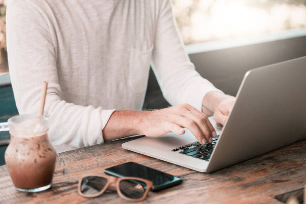 istock Young male freelancer sitting in cafe working in laptop 958084036