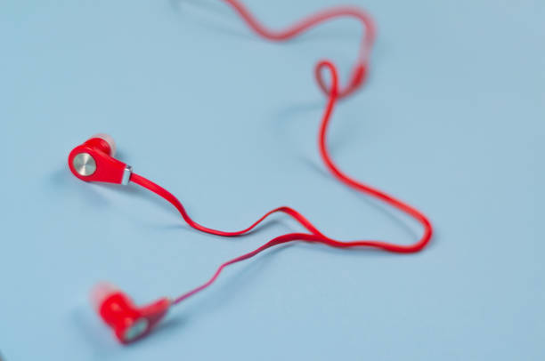 istock Red new earphone with cable on blue paper background 958086356