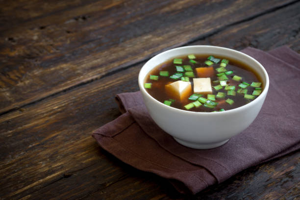 Miso soup Japanese miso soup in ceramic bowl on dark wooden background, copy space. Asian miso soup with tofu. miso sauce stock pictures, royalty-free photos & images
