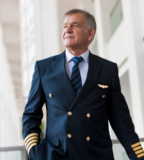 istock Experienced Senior pilot pulling his luggage in the airport terminal 958090204