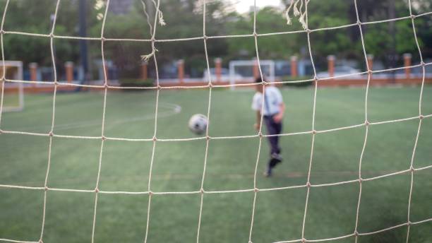 istock Asian boy playing soccer at school. 958090728
