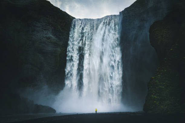 istock Hiker at gigantic Skogafoss waterfall in Iceland 958092246