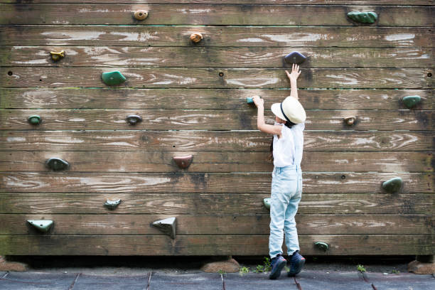 istock Little girl climbing the wall 958110108