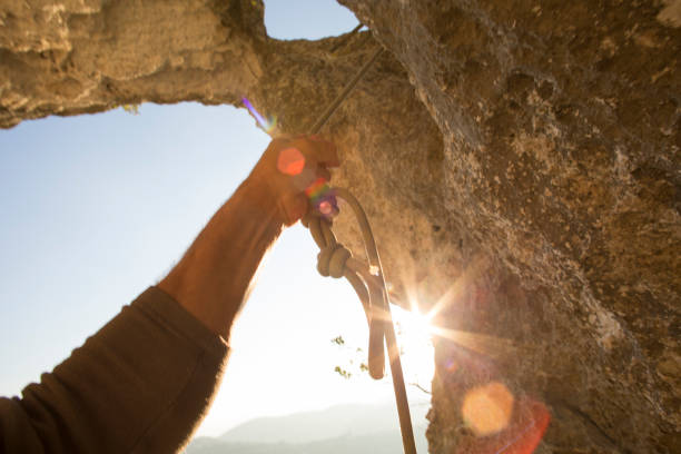 Arm extends out to pull rope tight through rock arch