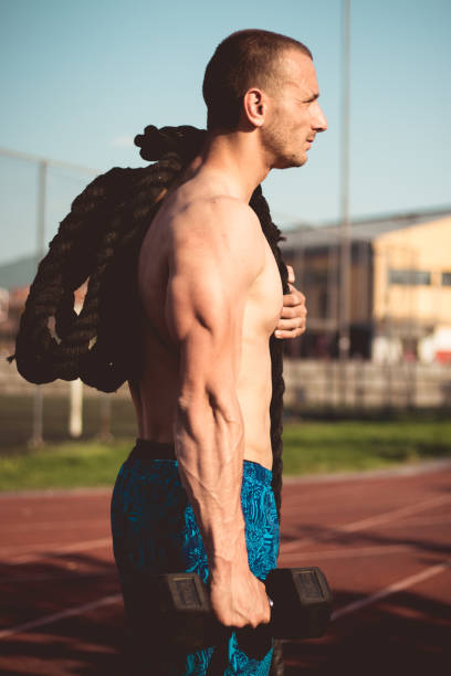 istock Athlete with a weight and a battle rope 958113358