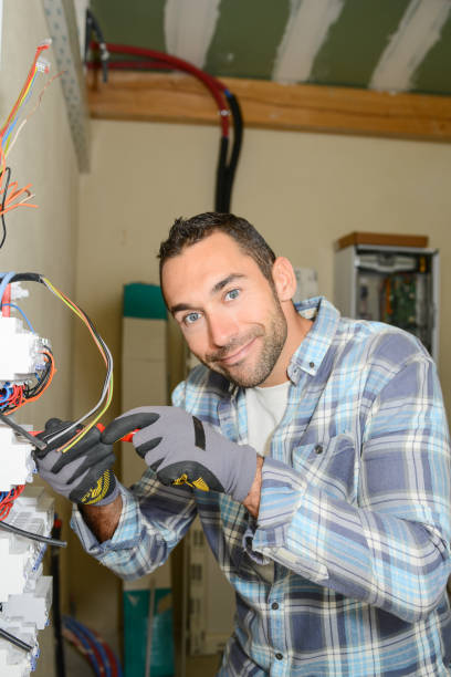 istock handsome young man electrician working on switchboard of house building construction site 958117768