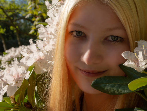 istock Attractive blond woman posing in spring flowers 958118726