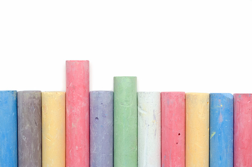 Assortment of colourful rainbow pencils on a mint green background. Top view flat lay, banner. School or office stationary, supplies.