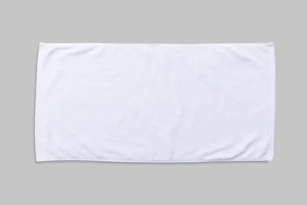 White beach towel mock up isolated with clipping path on grey background, flat lay top view