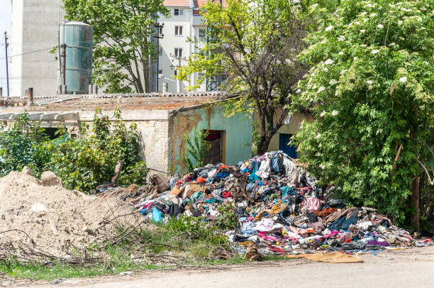 쓰레기와 환경 오염 하는 마당에 쓰레기와 함께 쓰레기통으로 사용 시에 새로운 주거 건물 근처 빈민가에 버려진된 농촌 손상 된 집 - abandoned built structure old ruin ghetto 뉴스 사진 이미지