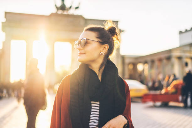 Portrait of a woman in front of Brandenburger Tor in Berlin, Germany Portrait of a young woman in front of Brandenburger Tor in Berlin, Germany at sunset brandenburg gate photos stock pictures, royalty-free photos & images