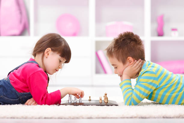 istock Little girl and boy playing chess 958125934