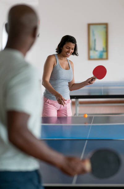 istock Diverse couple playing ping pong having fun at the hotel 958126530