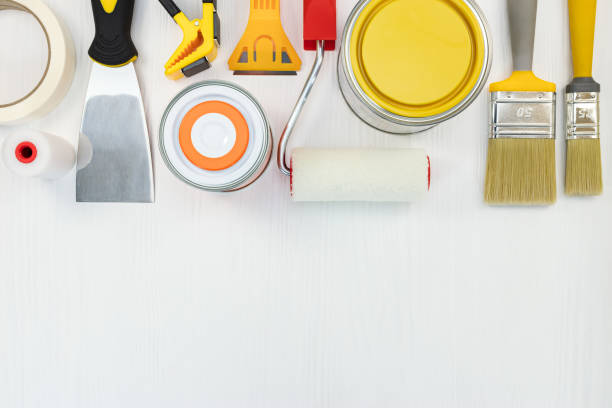istock paint cans, brushes, putty knife and rollers on white wooden background 958130422