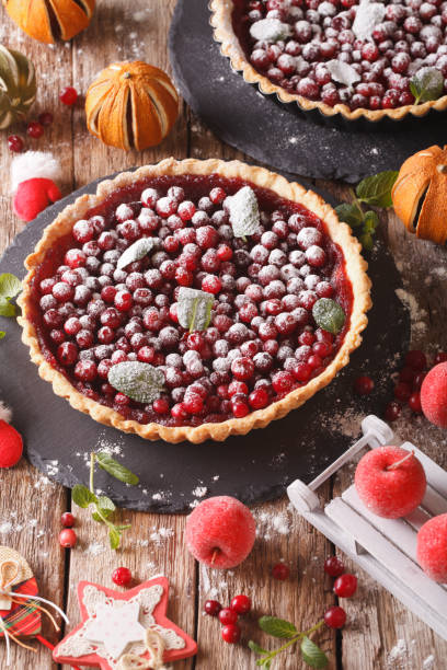 istock Christmas cranberry pie with icing sugar and festive decoration close-up on the table. Vertical 958135512