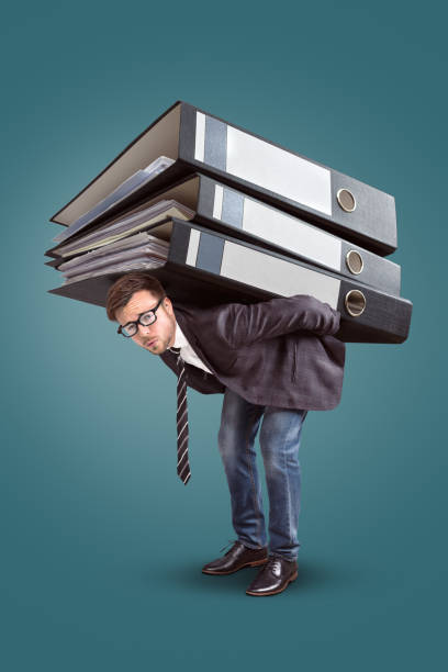 istock Man carrying a giant stack of folders 958135912