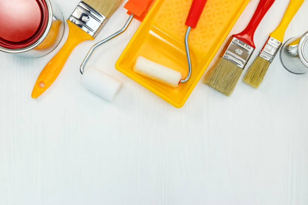 istock home renovation. set of paint brushes and rollers on white wooden background 958136052