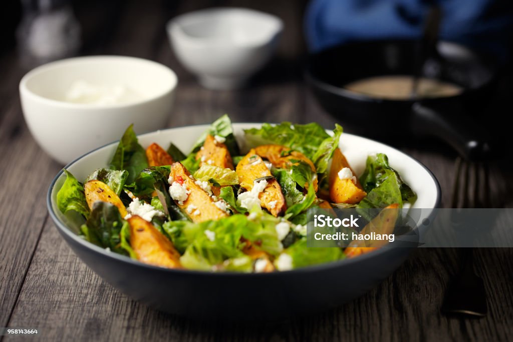 Healthy roasted sweet potatoes salad Home made freshness roasted sweet potatoes, cos lettuce and feta cheese flakes, pumpkin seeds Salad Stock Photo