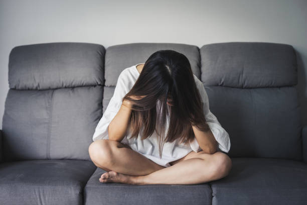 istock Depressed young woman holding hand on head 958150716
