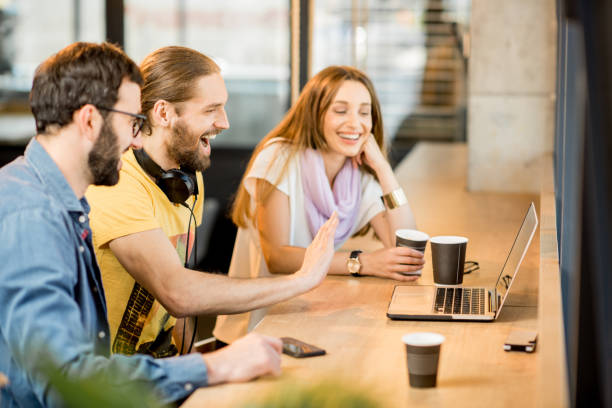 istock Happy colleagues with laptop in the cafe 958157598