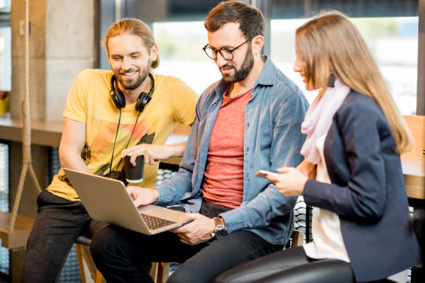 istock Young colleagues working with laptop in the cafe 958158174