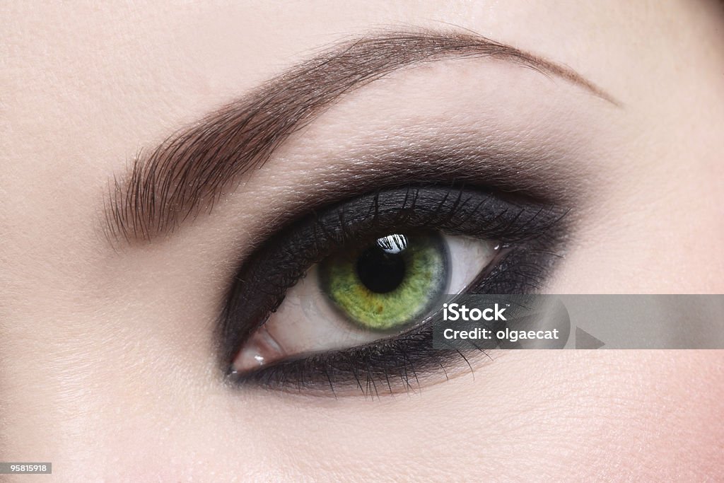 Woman's green eye with heavy makeup Macro shot of green woman's eye, selective focus Adult Stock Photo