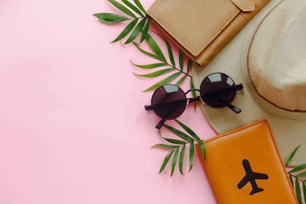 istock summer vacation concept, flat lay with space for text. passport with plane,hat and sunglasses on green palm leaves on pink background. modern travel and wanderlust image 958165956