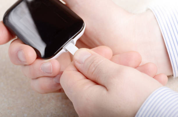 istock Man inserting blood test strip in glucometer for measurement 958170024