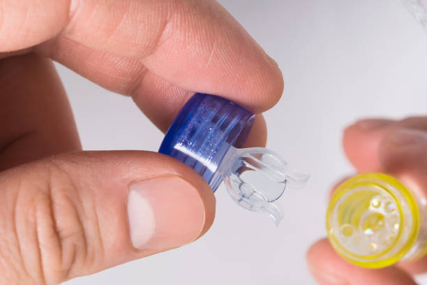 istock hands hold open container and lens for correcting close-up view 958174296