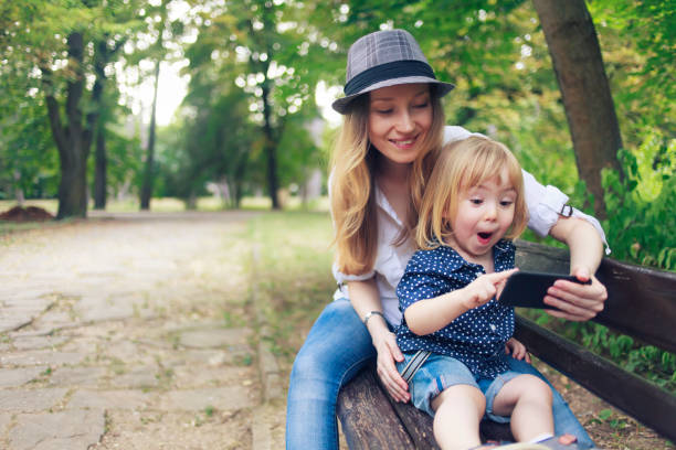 istock Mother and child making selfie in a park 958174492