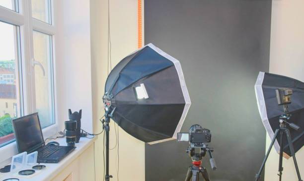 istock Empty photo studio with lighting equipment. Professional camera, lenses and filters for photographer 958177160