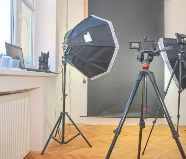istock Empty photo studio with lighting equipment. Professional camera, lenses and filters for photographer 958177222