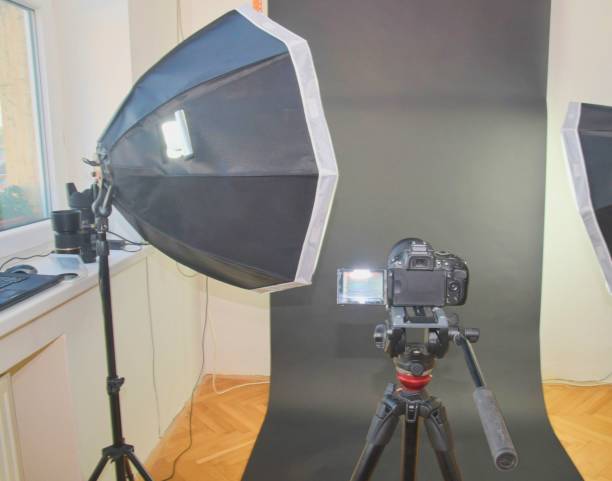 istock Empty photo studio with lighting equipment. Professional camera, lenses and filters for photographer 958177298
