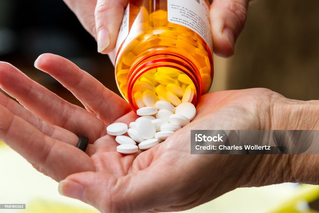 prescription meds close up of a hand handling prescriptions pills as a concept Opioid Stock Photo