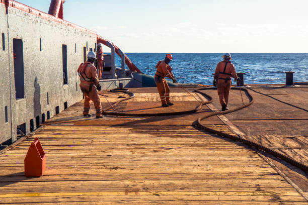 Anchor-handling Tug Supply AHTS vessel crew preparing vessel for static tow tanker lifting. Ocean tug job. 3 AB and Bosun on deck. They pull towing wire