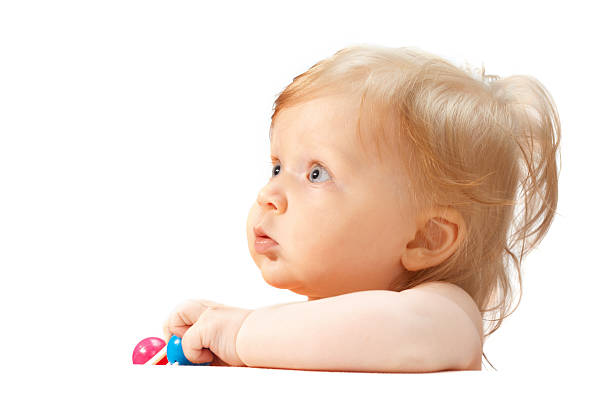Cute baby playing with colorful toy. New born child, little girl looking at the camera and crawling. Baby learning grab. figure four of the toy cubes