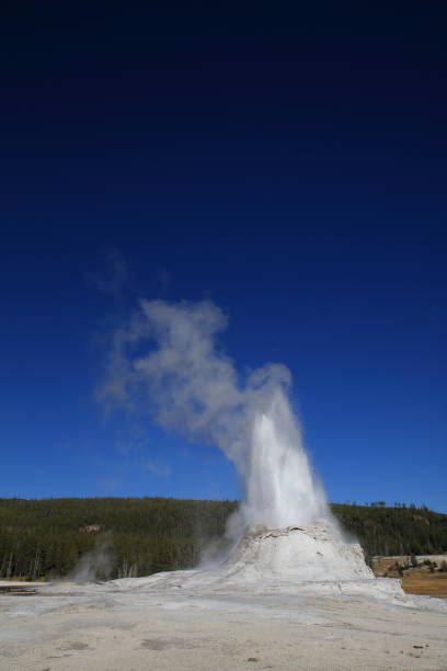 istock Yellowstone Castle Geyser erupting on background of blue sky 958201468