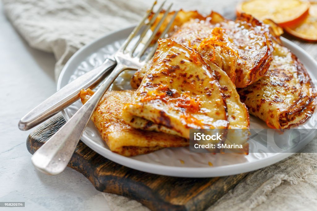 Thin crepes with orange sauce. Crepe Suzette with orange sauce for a delicious breakfast, selective focus. Crêpe - Pancake Stock Photo