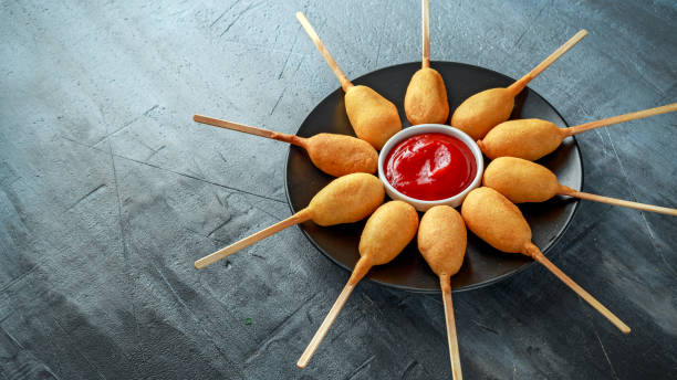 istock Mini Corn Dogs on black plate with ketchup 958213484
