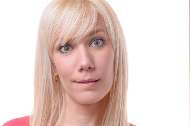 istock Quizzical blond woman biting her lip 958225998