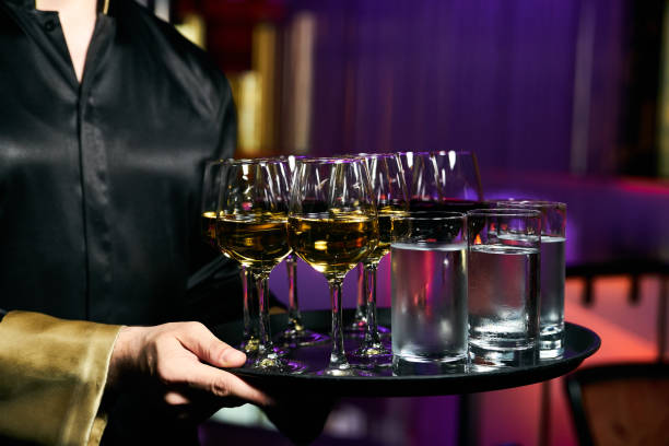 официант, обслуживающий шампанское и воду на подносе - waiter butler champagne tray стоковые фото и изображения
