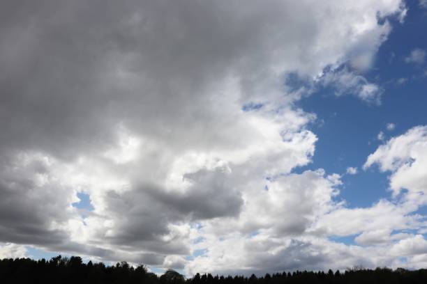 istock Fluffy white clouds and blue sky over rural landscape 958233594