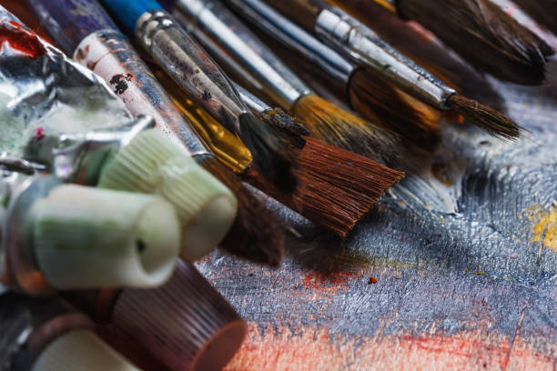 istock Artist paint brushes on wooden background 958237016