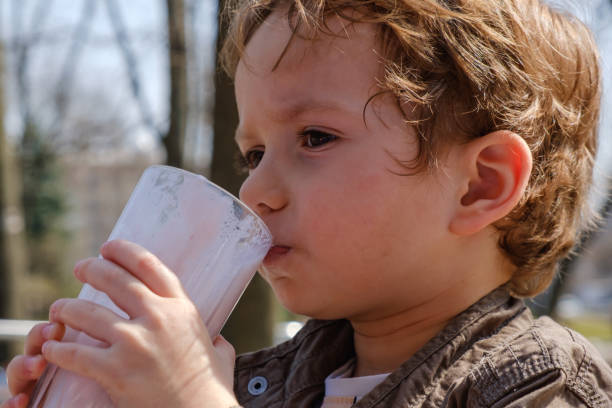 istock Little boy drinking strawberry milkshake 958240792